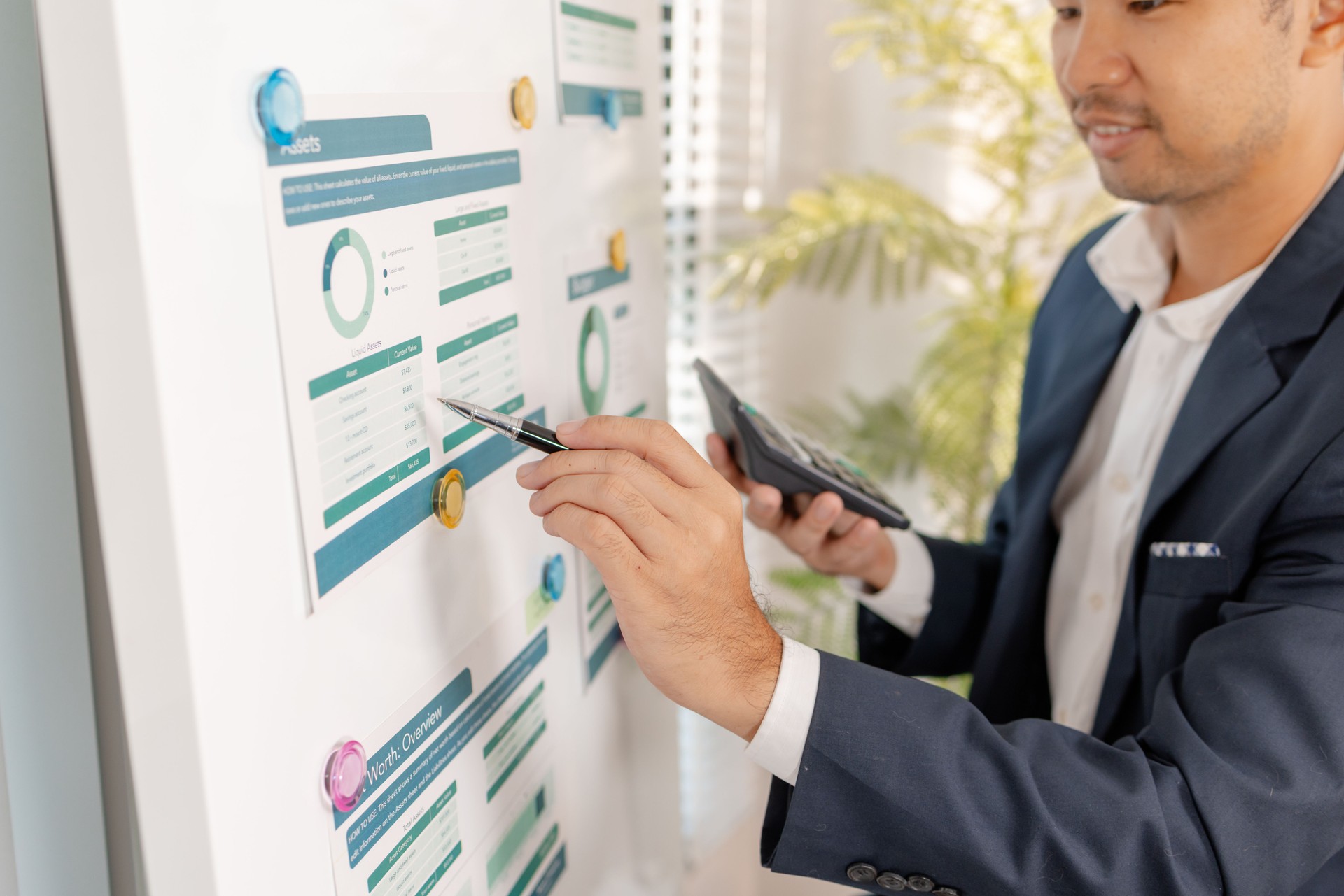A business analyst examining charts and statistics on a whiteboard, using data-driven insights to guide financial strategy, business performance, and future organizational planning.